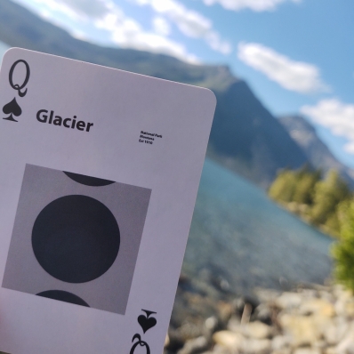 playing card in front of mountains and a lake