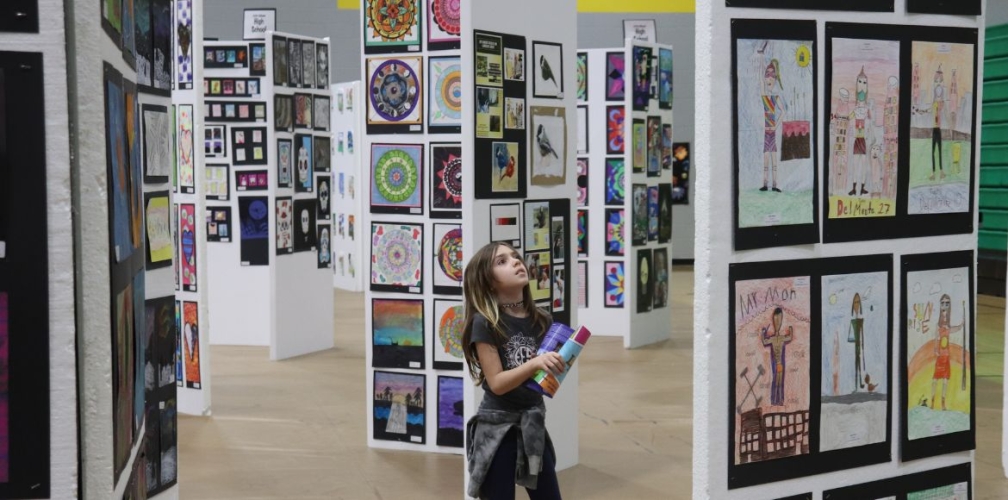 student looks up at art